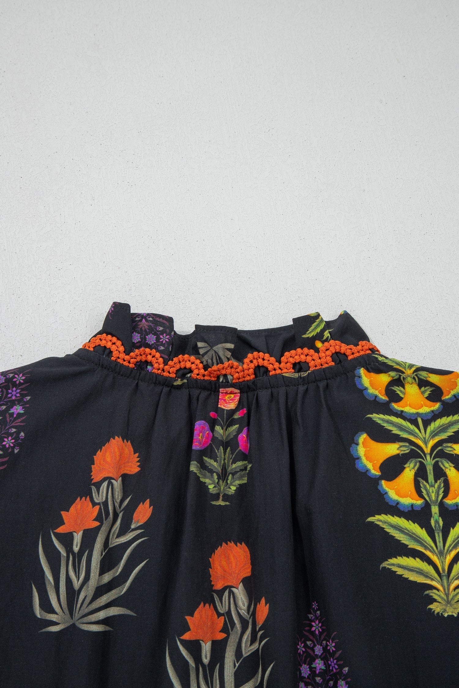 Camisa negra con flores, borde de encaje y escote en V con volantes