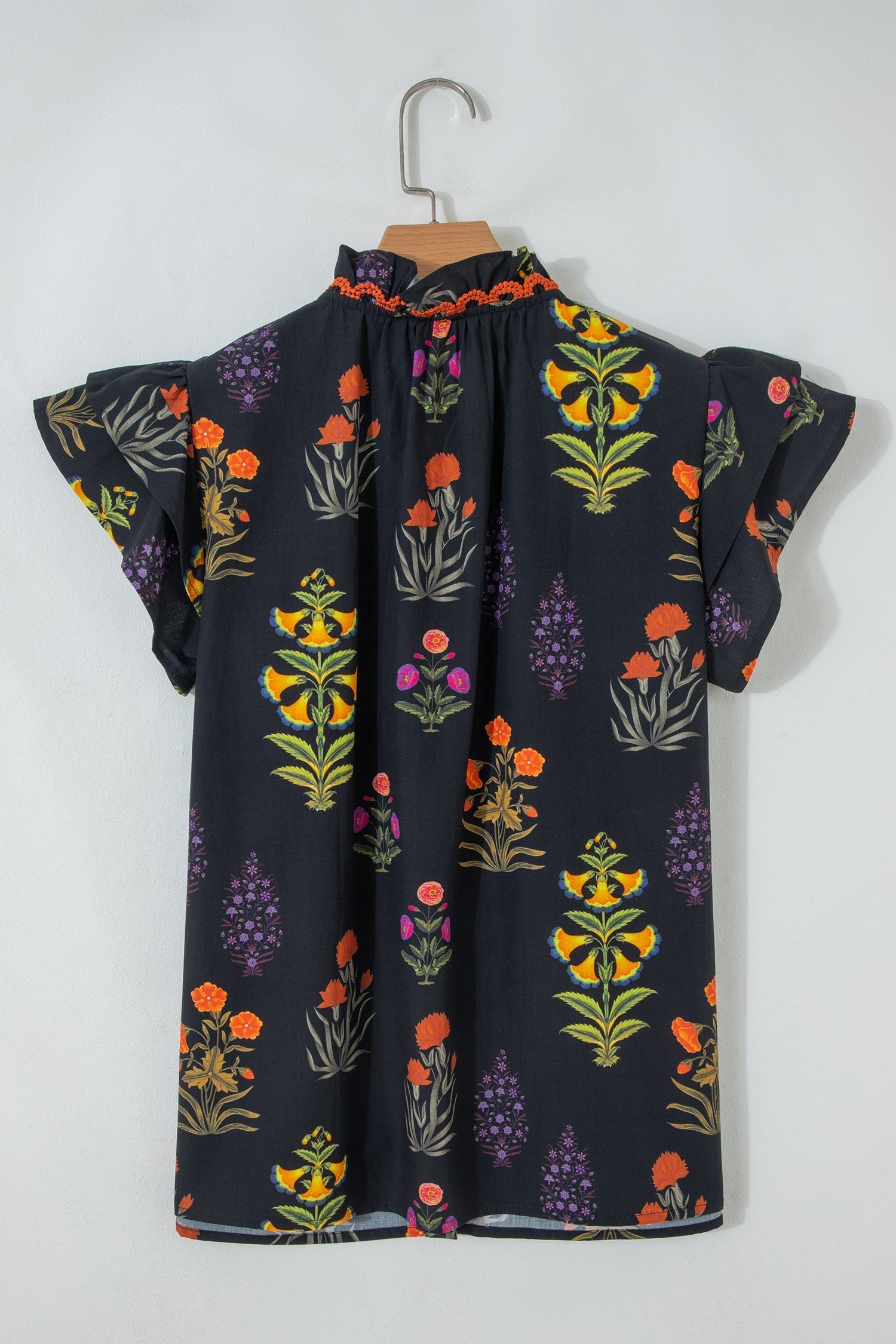 Camisa negra con flores, borde de encaje y escote en V con volantes
